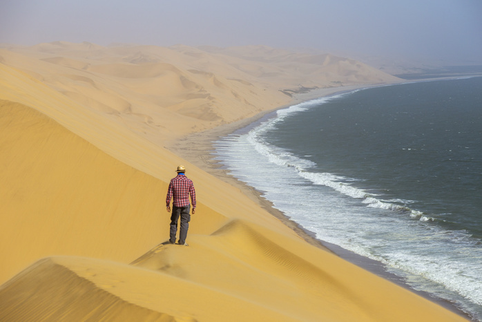 Namibia Sandwich Harbor Between desert and ocean a man admires the view,Sandwich Harbour,Namib Naukluft National Park,Namibia,Africa Photo by Filippo Manaigo