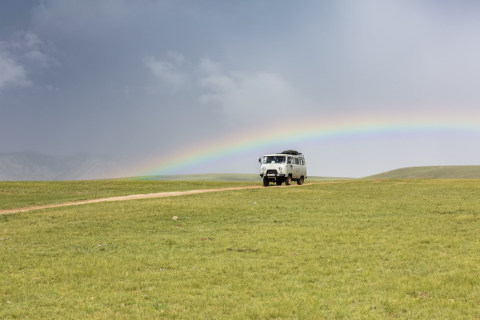 Mongolia Rainbow and Soviet vehicle driving in the Mongolian steppe. Ovorkhangai province, Mongolia. Photo by Francesco Vaninetti