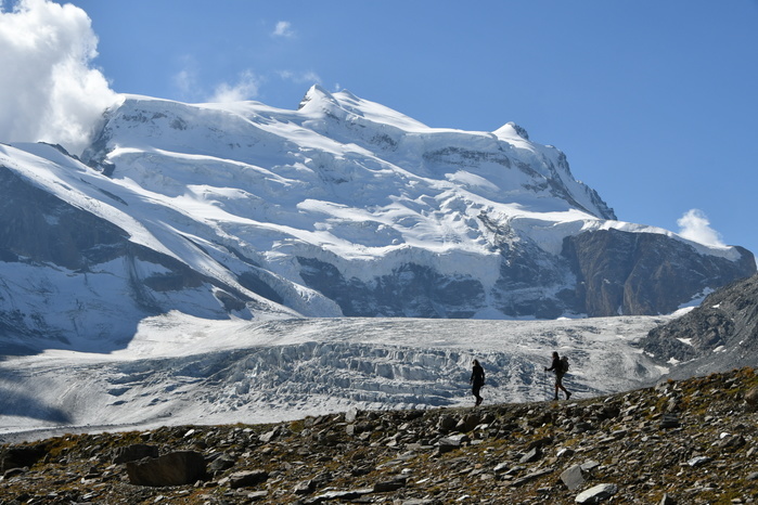 Switzerland Trekkers with huge glacier behind, Grand Combin North Face, path to Panossiere hut, Switzerland,Swiss Photo by Marco Gabbin