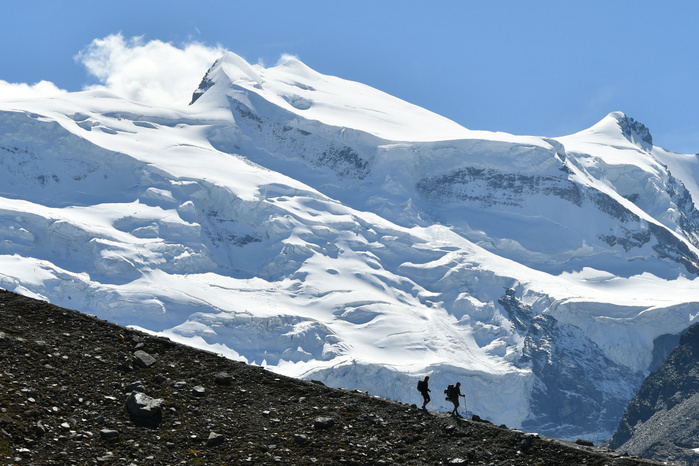 Switzerland Trekkers with huge glacier behind, Grand Combin North Face, path to Panossiere hut, Switzerland,Swiss Photo by Marco Gabbin