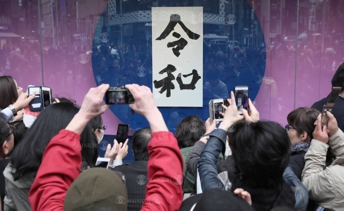 People take photos of calligrapher Hiromitsu Ishitobi s calligraphy of the new year in front of Wako in Ginza. People take photos of calligrapher Hiromitsu Ishitobi s calligraphy of the new year s name in front of Wako in Ginza, Tokyo, at 0:58 p.m. on April 1, 2019  photo by Junichi Sasaki .