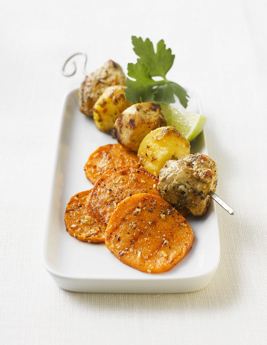 Turkey hen skewers with mango and sweet potato slices on platter