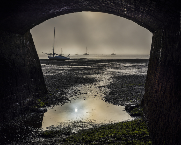 Boats on the Exe estuary in heavy fog viewed through an arch under the Exmouth to Penzance railway line, Starcross, Devon, UK Boats on the Exe estuary in heavy fog viewed through an arch under the Exmouth to Penzance railway line, Starcross, Devon, England, United Kingdom, Europe, Photo by Baxter Bradford