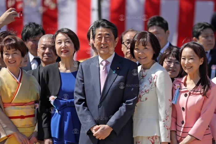 Prime Minister Shinzo Abe and his wife  center right  pose for a photo with guests at the  Cherry Blossom Viewing Party. Prime Minister Shinzo Abe and his wife  center right  pose for a commemorative photo with invited guests at the  Cherry Blossom Viewing Party  at Shinjuku Gyoen in Shinjuku Ward, Tokyo, April 13, 2019  photo by Shinnosuke Kiyatake .