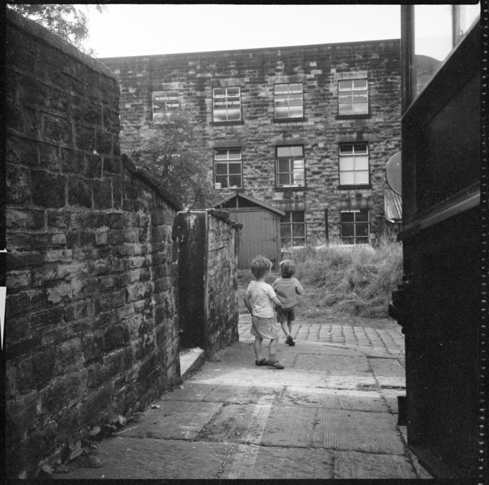 Holker Street Mill, Burnley Road, Colne, Pendle, Lancashire, 1966 1974. Creator: Eileen Deste. Holker Street Mill, Burnley Road, Colne, Pendle, Lancashire, 1966 1974. Holker Street Mill seen from the lane running between 48 Burnley Road and Bethel Church, with two children playing in the lane.