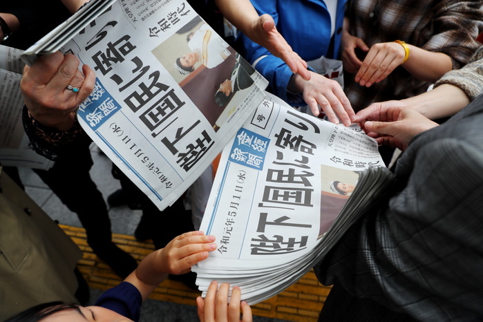 The first day of the Reiwa Era People try to receive a copy of extra edition of a newspaper reporting new emperor Naruhito s ascension on the front page in Tokyo s Ginza shopping district, Japan on May 1, 2019, the first day of the Reiwa Era.  Photo by Naoki Nishimura AFLO 