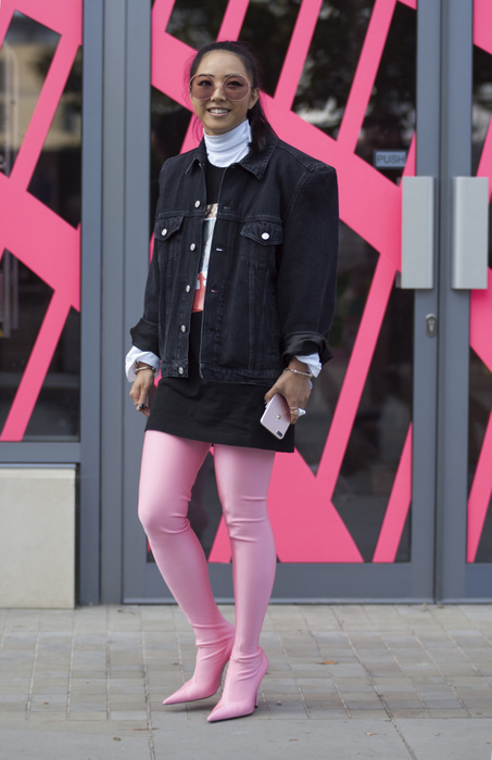 London Fashion Week, Spring Summer 2018 : Street style Street Style from Day three of London Fashion Week, Spring Summer 2018, on Sunday September 17th 2017. Image shows Yuyu Zhangzou wearing a denim jacket, a mini skirt, T Shirt and pink high heel legging boots, all by Versus versace