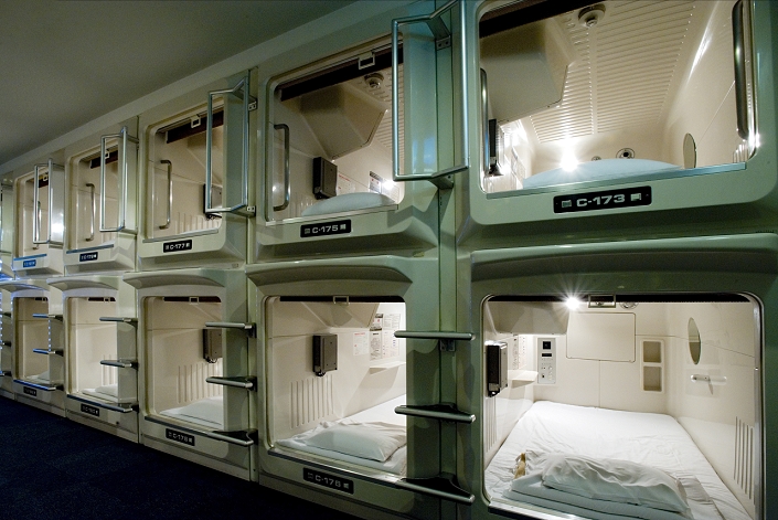 Japan Rows and stacks of sleeping compartments along one corridor at a capsule hotel in Osaka, Japan, Asia