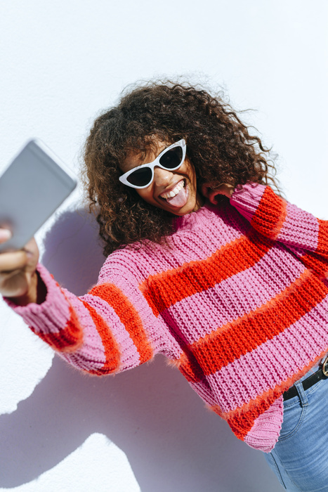 Portrait of young woman wearing sunglasses taking selfie with mobile phone Portrait of young woman wearing sunglasses taking selfie with mobile phone