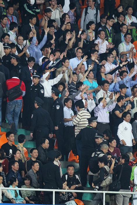 Guangzhou Asian Games Soccer Men Japan fans  JPN , NOVEMBER 8, 2010   Football : Japanese fans celebrate after their team defeated China as Chinese police officers and security workers stand guard around them following the first round of Group A soccer match of the Asian Games in Guanghzou, China, Monday, Nov. 8, 2010. Japanese fans celebrate after their team defeated China as Chinese police officers and security workers stand guard around them following the first round of Group A soccer match of the Asian Games in Guanghzou, China, Monday, Nov. 8, 2010.  Photo by AFLO SPORT   1090 .