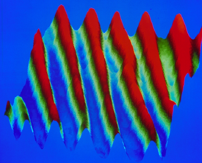 Silver nanowires. Coloured atomic force micrograph (AFM) of silver nanowires (red). The nanowires lie about 20 nanometres apart on a calcium fluoride crystal. They were assembled from clusters of several thousand silver atoms using the tip of the AFM. Nanowires could be used for miniature electronics or as a substrate for growing artificial tissue. Atomic force microscopy involves scanning an object by moving a spring- loaded 'stylus' over it. Magnification: x250,000 at 6x4.5cm size.