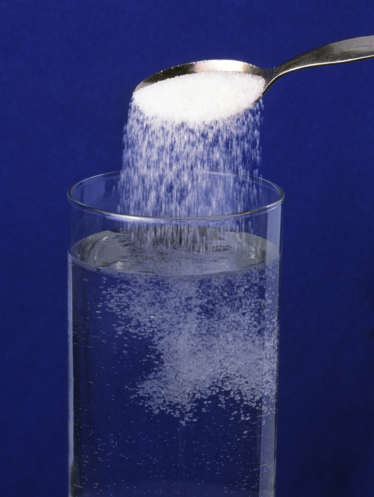 Dissolving sugar. Sugar dissolving in a glass of water as it is poured from a spoon. Dissolving occurs because there is electrostatic attraction between the water molecules and the sugar molecules. This means that the water pulls sugar molecules away from the surface of the grains and into the fluid. In this way the sugar (the solute) dissolves into the water (the solvent) to form a homogeneous mixture (solution). The amount of dissolved sugar that water can hold in solution depends upon the fluid's temperature and pressure. When no more sugar will dissolve the solution is said to be saturated.