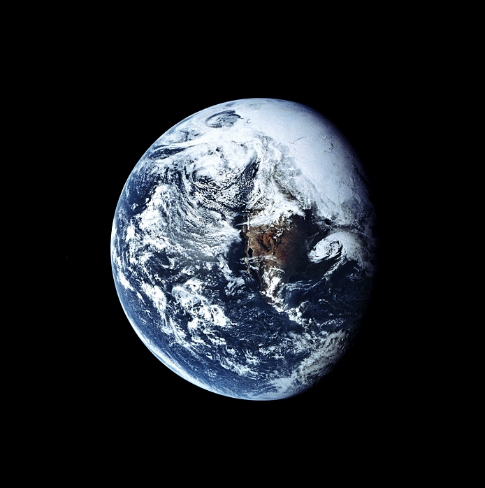 America from space, centred on Mexico. Water is blue, land is brown, snow & ice is white as are clouds. The Pacific Ocean (left) boarders the northern and central American continent (brown). The Arctic ice cap is seen at upper right (solid white). Photographed by the crew of the Apollo 16 mission of 1972 (16-27 April), en route to the Moon.