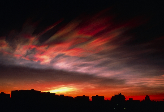 Nacreous cloud. View of a nacreous cloud illuminated by the sun after it has moved below the horizon. Nacreous clouds are a rare cloud form characterised by an iridescent appearance. They are most noticeable after sunset when they are seen against a dark background, as here. They are high-altitude clouds, typically forming at around 20-25 kilometres above the ground. They are usually only visible from areas around the poles at times when stable low pressure weather systems prevail. This cloud was photographed in Finland in January 1997.
