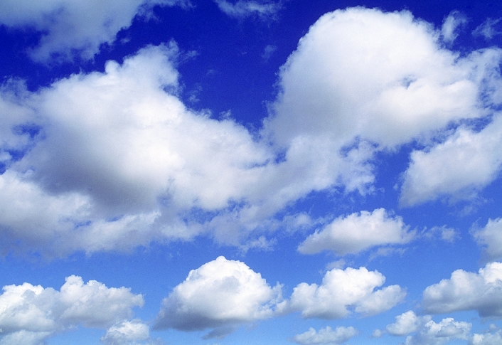 Cumulus clouds. Fluffy cumulus clouds in a blue sky. Cumulus clouds have a puffy, cotton wool appearance, and may indicate impending rain.