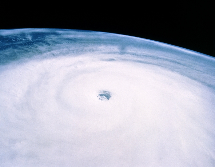 The massive anticlockwise swirl of cloud associated with Typhoon Yuri, photographed by the crew of Shuttle Mission STS-44 at the end of November 1991. Typhoon Yuri originated about 1,500km east of the Philippine Islands in the Pacific Ocean. At this point, the cloud deck is some 1,700km in diameter, with the calm and almost cloudless 'eye' of the storm seen at centre. Wind speeds on the ground were often measured at a sustained 230km per hour, with gusts reaching 270km per hour. Typhoons, or tropical cyclones, develop over ocean areas at least 5 degrees latitude above the equator and where the surface water temperature is over 27 Celsius.
