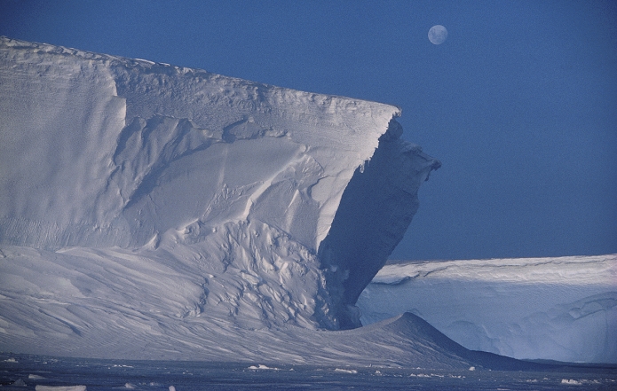 Ice cliffs, 25 metres high, at the edge of the Brunt Ice Shelf, Antarctica, with the moon above.