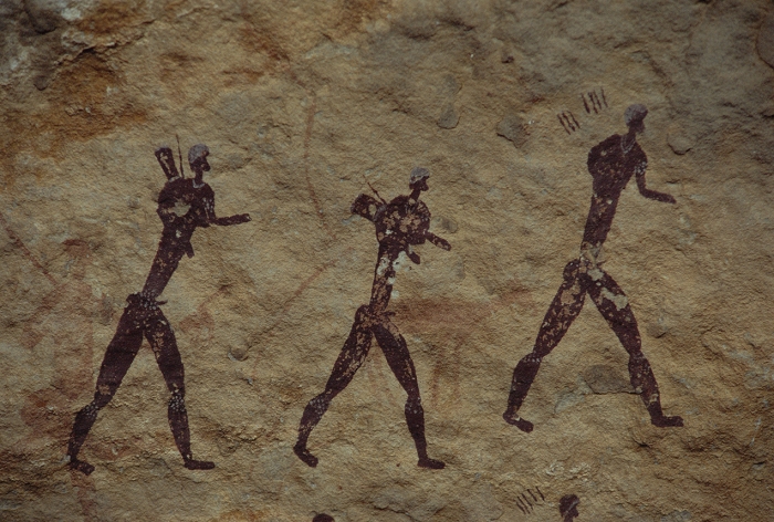 San rock art depicting hunters marching. The San people (also known as Bushmen) who painted these pictographs once inhabited all of southern Africa. They were displaced by the Bantu people into the deserts and high mountain country. European settlers, arriving in the interior from the coast of southern Africa, drove the mountain San to extinction by the start of the twentieth century. The rock paintings were thought to be around 1000 years old, but more recent research estimates that they are nearer 3000 years old. Photographed in Cobham Nature Reserve, Natal Drakensberg Park, South Africa.
