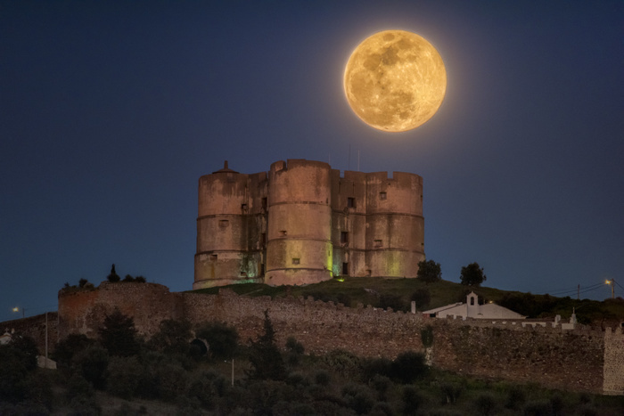 Supermoon over Tower of Evoramonte Supermoon over Tower of Evoramonte. A supermoon is a Full Moon that occurs when the Moon is at its perigee, its closest approach to the Earth. In addition to this, the Full Moon rising near the horizon results in an optical illusion that makes the Moon appear larger than it is compared to objects in the foreground. Photographed on 20 March 2019, in Evoramonte, Portugal.