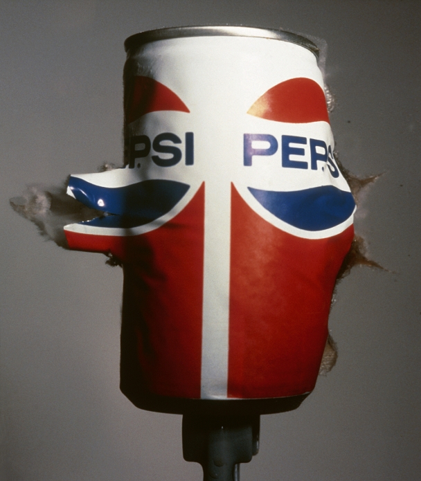 High speed photograph of a . 22 calibre bullet passing through a Pepsi can. The entire surface of the can has become wrinkled due to the impact. The bullet is travelling at about 450 metres per second (Mach 1.4).