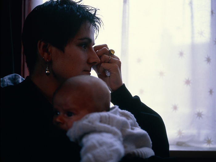 . Postnatal depression. Woman suffering from postnatal depression holding her baby. This depression is probably caused by the sudden hormonal, physiological and environmental changes that occur after the birth of a baby. Postnatal depression is usually quite mild and takes the form of irritability and tearfulness. It will usually pass within two or three days. Sometimes the depression is more serious and can result in suicidal tendencies and delusions. When this happens treatment takes the form of anti- depressant drugs, hospital care and counselling. MODEL RELEASED