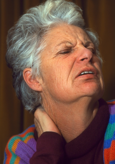 . Neck pain. Elderly woman holds her neck in an expression of pain. Neck pain of unknown origin is very common and is not usually serious. In the elderly, pain is often caused by osteoarthritis of the neck bones (vertebrae). Osteoarthritis is characterized by degeneration of the cartilage that lines the joints between bones. It is aggravated by mechanical stress and leads to pain and stiffness in the affected joints. MODEL RELEASED