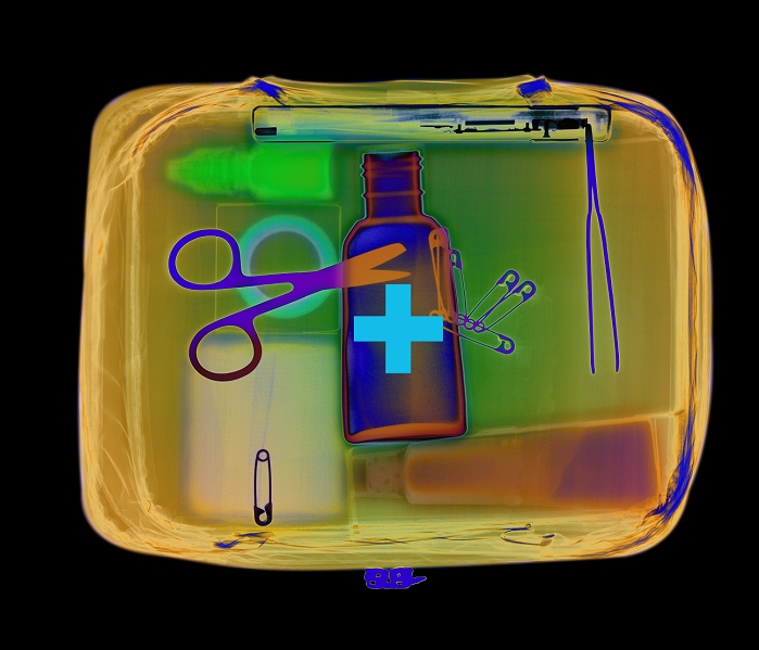 First aid kit. Coloured X-ray of a first aid kit in a carrying container. Inside it can be seen a pair of scissors, forceps, safety pins, bottle of antiseptic, container of cream, eye drops, bandage and tape. First aid is applied immediately after an accident and is intended to stabilise a patient's condition until they can receive proper medical attention.