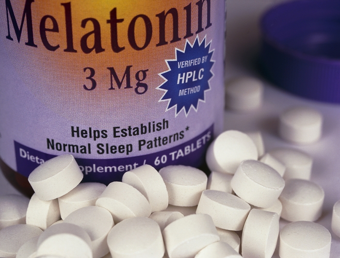 Melatonin pills. Bottle with pills of melatonin, a hormone which controls the biological clock and induces sleep, and is claimed to slow aging. Melatonin is produced naturally by the pineal gland in the brain. Secreted at night, it helps to control sleep and set the biological clock. In middle age, melatonin secretion drops off and may be responsible for symptoms of aging like insomnia and irritability. As a drug melatonin can be taken by people aged over 40 just before they go to bed. By assisting the rhythm of sleep, the body is more rested when awake. In this way it is thought that the aging process may be slowed. Melatonin is also used successfully to prevent jetlag.
