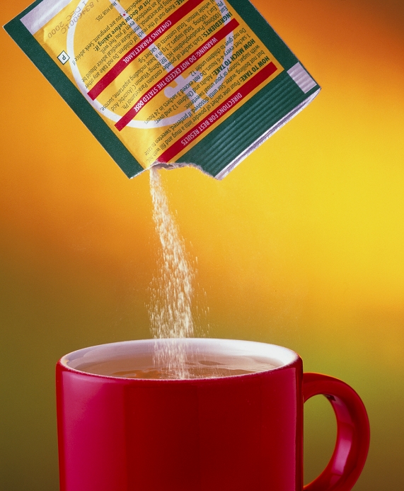 Lemsip cold and flu remedy pouring from a sachet into a mug of hot liquid. This lemon- flavoured soluble powder contains the analgesic (painkiller) paracetamol, the decongestant pseudoephedrine and vitamin C. Lemsip is produced by Reckitt and Colman Products.