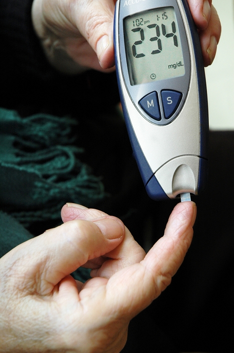 . Blood glucose test. Close-up of a 78 year old woman using a glucometer to measure the amount of glucose in her blood. Diabetics have to perform this test regularly. The glucometer is showing a high reading, between 1 and 2 is normal, and so the women will need an insulin injection. Diabetes is a metabolic disorder in which unused sugars accumulate in the blood and urine. Monitoring of blood glucose levels allows diabetics to control the disease through diet, medication and in some cases insulin injections. MODEL RELEASED