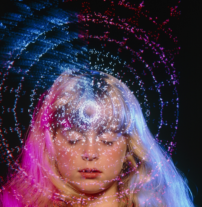 Meditation. Abstract image of a young girl with closed eyes in the process of meditation or prayer, with concentric circles of coloured light superimposed. This projected image over her face and concentrated on her forehead suggests a state of increased mindfulness or spirituality. Meditation is known to relieve stress, and discipline the breathing and posture.