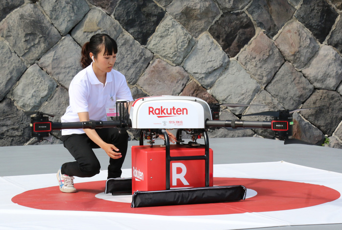 Rakuten and Seiyu have a demonstration of drone delivery service as they will start the service June 17, 2019, Yokosuka, Japan   A woman receives a box as a drone arrives at Sarushima island off the coast of Yokosuka in Tokyo Bay for a demonstration of a drone delivery service from Yokosuka, some 2km far from Yokosuka on Monday, June 17, 2019. Japanese e commerce giant Rakuten and Walmart s subsidiary Seiyu supermarket chain will launch a drone delive service between Sarushima island and Seiyu s shopping mall in Yokosuka city from July 4 as the remote islnad has no supermarket and convenience store.    Photo by Yoshio Tsunoda AFLO 