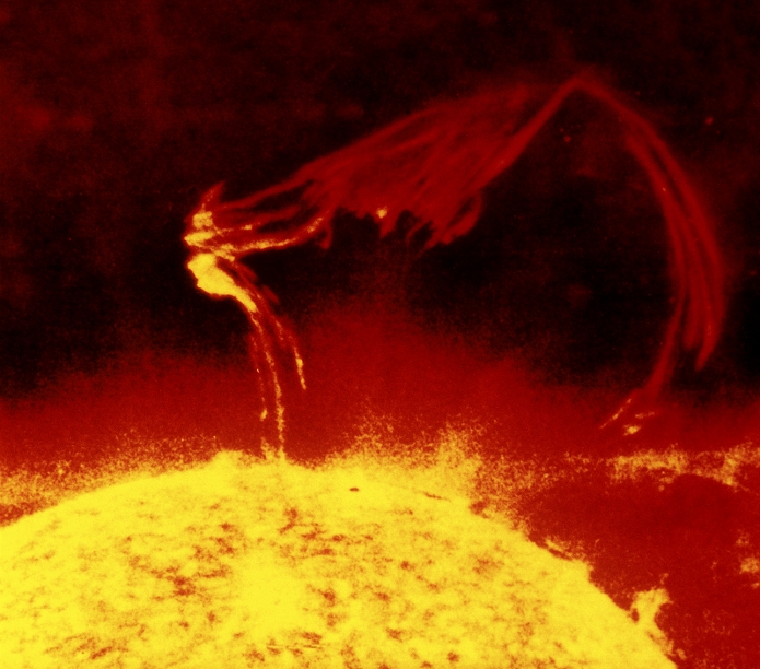 Solar flare, Skylab 1 image. This flare, or prominence, is erupting from the chromosphere (orange), which lies above the Sun's visible surface. Prominences are dense clouds of plasma, or ionised gas, in the Sun's outer layer, the corona. Upon erupting, the flares become part of the solar wind. They may be associated with strong magnetic activity inside the Sun, and some flares are powerful enough that, on reaching Earth, they can disrupt telecommunications and satellite systems. Solar flares can extend hundreds of thousands of kilometres into space.