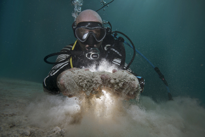 Testing sand consistency on the seabed Testing sand consistency on the seabed. Diver manually testing the consistency of the sand on the seabed. As well as manual tests, sensors can be used to test for a range of pollutants, and an analysis carried out of the composition of the sand. Photographed in 2018 in the Mediterranean, off the coast of Spain.