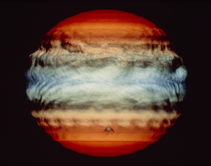 Comet Shoemaker-Levy impact on Jupiter, July 1994. Last in a series of five frames from a computer simulation, showing the effect of the impact of a 1-km diameter comet on the atmosphere of Jupiter. The altitude scale in the model is exaggerated, giving the atmosphere a 'lumpy' appearance. This frame shows Day 4, three days after the impact. Large waves are seen in the atmosphere, moving from the point of impact (lower centre) and disrupting the 'bands'. Over 20 1-km or larger fragments from Comet Shoemaker-Levy 9 are due to hit Jupiter on 18-24 July 1994. The comet was broken up by Jupiter's gravity during a close encounter in July 1992.