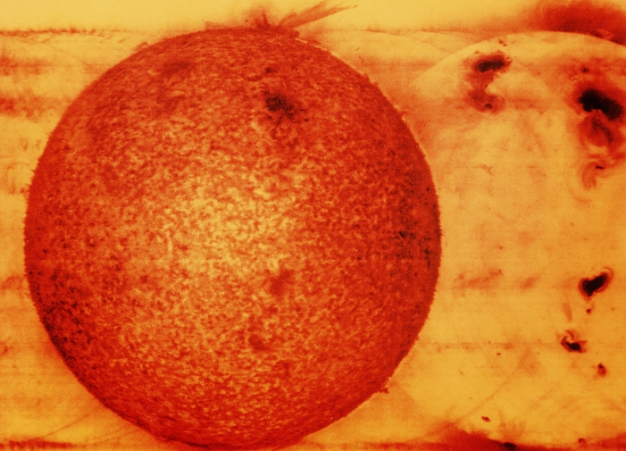 Extreme ultraviolet image of the Sun, showing an eruptive prominence (top). The photograph was taken from the Skylab 2 space station on 10 June, 1973. Prominences occur in the Sun's chromosphere & corona and are composed of glowing, incandescent gas in the form of loops, jets or arches. They are of two types: eruptive & quiescent. Eruptive prominences, such as this, are in violent motion & may extend outward for more than 700,000 km above the Sun's surface. Quiescent prominences are more stable & may hang around in the chromosphere for weeks before breaking up. They are best seen when jutting out from the Sun's limb.