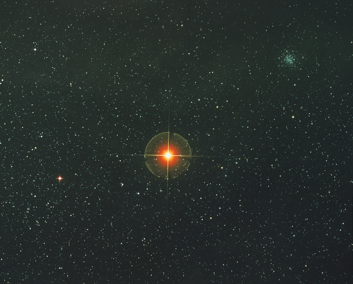 ^BTHIS PICTURE MAY NOT BE USED TO STATE OR IMPLY ^BROE'S ENDORSEMENT OF ANY COMPANY OR PRODUCT. *** THIS PICTURE MAY NOT BE USED TO STATE OR IMPLY   ROE ENDORSEMENT OF ANY COMPANY OR PRODUCT *** Starfield with Antares (alpha Scorpii), a red supergiant star 500 light years from the Earth. The red supergiant phase is one of the final stages in the life of a normal star, when almost all its hydrogen content is burnt. In this phase the outer layers of the star are greatly inflated by a thin shell of hydrogen burning around a central core of helium. Antares has a diameter of roughly 1 billion km, a surface temperature of 3100K and a mass 10-15 times the solar mass. The globular star cluster NGC 6144 is at top right.