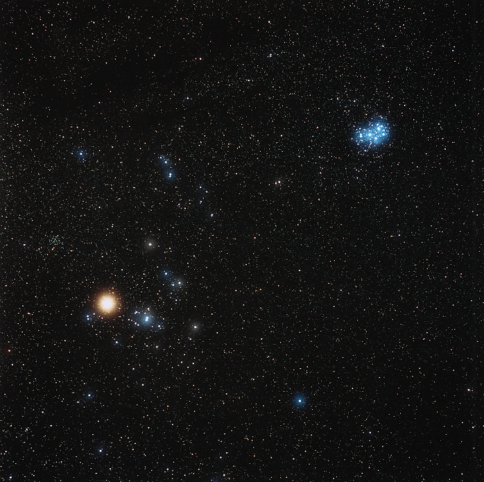 Star clusters. Optical image of the Hyades (lower left) and Pleiades (M45, upper right) open star clusters in the zodiacal constellation Taurus, the bull. North is at top. The bright orange star is Aldebaran (Alpha Tauri), which is a foreground star and is not part of the Hyades cluster. The Hyades is a cluster of young stars which lies around 130 light years from Earth. Its stars are thought to be around 400 million years old. The Pleiades is an even younger cluster. Its stars are swathed in nebulosity, thought to be the remnants of the gas cloud from which they formed some 50 million years ago.