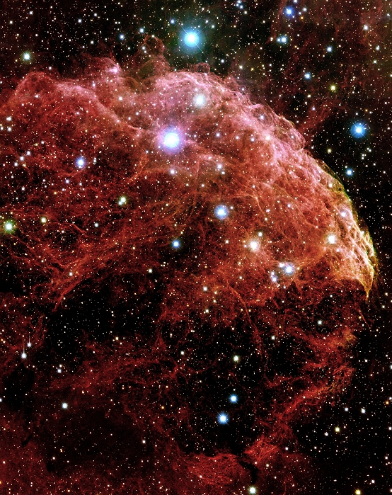 Supernova remnant IC 443, optical image. This is part of a shell of gas that was ejected by a supernova, the explosive death of a massive star. The gas is glowing as it collides with a dark, cool cloud of molecular gas. This collision excites the hydrogen molecules, causing them to emit red light. It is thought that the supernova explosion responsible for this shell of gas occurred around 8000 years ago. IC 433 lies in the constellation Gemini.