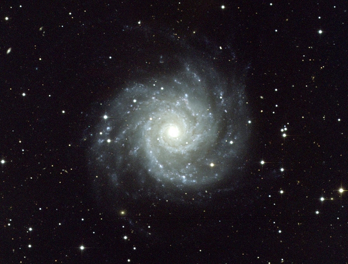 *** THIS PICTURE MAY NOT BE USED TO STATE OR IMPLY  NOAO ENDORSEMENT OF ANY COMPANY OR PRODUCT *** Spiral galaxy M74. Optical image of the spiral galaxy M74 (NGC 628), a face-on spiral galaxy with a small nucleus and well-defined spiral arms. The nucleus appears yellow/white as it is populated mainly by older stars. The spiral arms contain more young blue stars, and some large starbirth regions (bright knots) can be seen. These are huge clouds of gas and dust which glow as their gas is ionised by the hot young stars which formed from them. This galaxy lies around 30 million light years from Earth in the constellation Pisces.