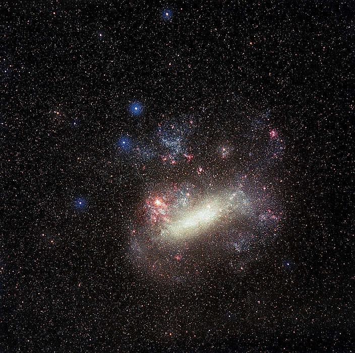 Large Magellanic Cloud. Optical image of the Large Magellanic Cloud (LMC), a satellite galaxy of our Milky Way, in the constellation Dorado, the swordfish. North is at top. This galaxy is the nearest galaxy to the Milky Way, lying around 170,000 light years away. The large pink area on the left edge of the LMC is the Tarantula Nebula (NGC 2070). This is a huge emission nebula, a starbirth region which glows pink due to the ionisation of the hydrogen gas it contains by radiation from hot young stars within it. It is one of the largest and most powerful emission nebulae known.