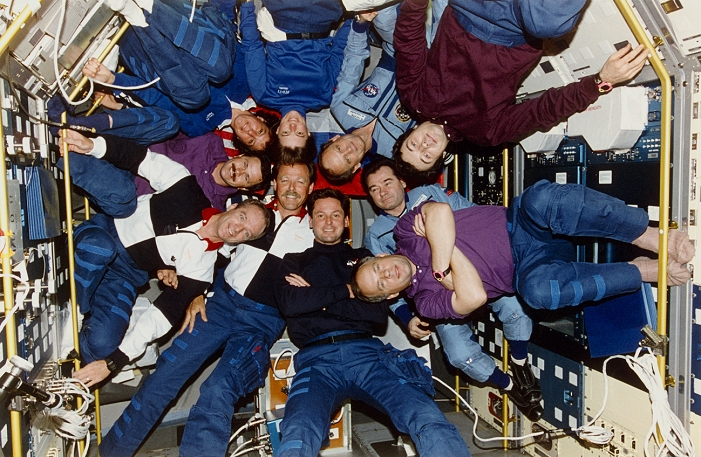 First Shuttle-Mir mission. The crews of Shuttle Mission STS-71, Mir-18 and Mir-19 pose for an in- flight portrait. This was the first joint mission between the USA and Russia for 20 years. The crew members are (clockwise from bottom centre): Gregory Harbaugh, Robert 'Hoot' Gibson, Charles Precourt, Nikolai Budarin, Ellen Baker, Bonnie Dunbar, Norman Thagard, Gennadiy Strekalov (dark shirt), Vladimir Dezhurov (pale blue suit) and Anatoly Solovyev (purple shirt and socks). Mission STS-71 flew on 27 June to 7 July 1995, carrying the Mir-19 crew to the space station and returning the Mir-18 crew to Earth.