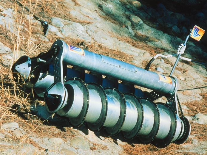 Robot mine detector. A prototype remote-controlled robot mine detector which can move over almost any terrain to trigger mines or traps ahead of troops. Invented in 1995 by Bill Battenburg of Lawrence Livermore National Laboratory, California, it moves on two 1.2-metre screw-like wheels that can carry it over rocks, mud and water, and up hills and stairs. When both screws turn in the same direction, it moves swiftly sideways; when the screws turn in opposite directions, it crawls forwards. It can also be fitted with cameras or other sensors and devices to disarm weapons, pull sniper fire, or sniff out toxins.