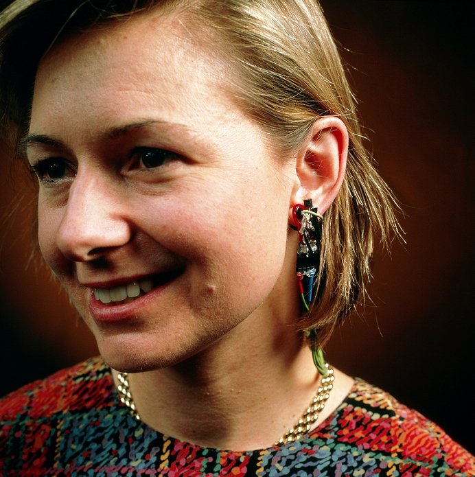 Wearable computing. Woman wearing a prototype stress-detecting earring, a type of affective computer. The earring calculates the woman's blood pressure by measuring the amount of light reflected by the skin of her ear from a light source. If she is frightened or anxious, her blood pressure will increase. Affective computers provide feedback about the wearer's physical state or behaviour, such as indicating if their wearer's stress levels are too high. This earring was created at the Media Lab of the Massachusetts Institute of Technology (MIT), USA.