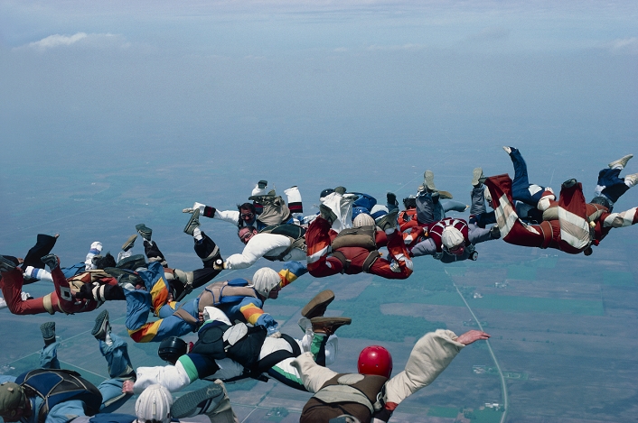 A 'star' formation of 18 skydivers in free-fall. The skydivers jump from aircraft at an altitude of around 12,500 ft, giving some 50 seconds of free- fall time in which to gather together in such formations. The skydivers are falling at the terminal velocity, approximately 125 miles per hour. The world record for formation skydiving is a star of 144 parachutists, held for 9 seconds over Illinois , USA, in 1988.