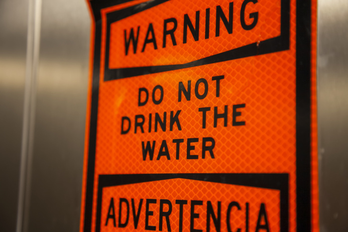 An orange sign warning 'do not drink the water'; Galveston, Texas, United States of America, Photo by Blake Kent