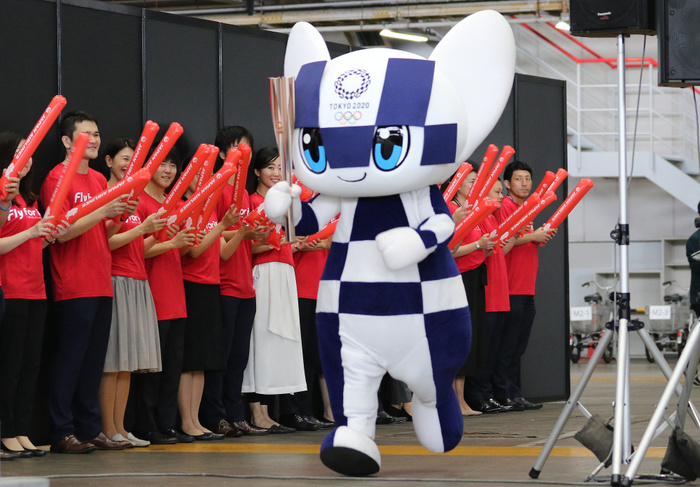 JAL displays the new uniforms for their staffs July 23, 2019, Tokyo, Japan   Tokyo 2020 Olympic mascot Miraitowa carries the Olympic torch at the JAL hangar of the Haneda airport in Tokyo on Tuesday, July 23, 2019. JAL announced they will serve as supporting partner of the Tokyo 2020 Olympic torch relay.     Photo by Yoshio Tsunoda AFLO 