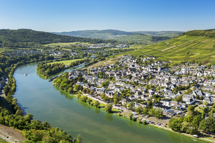 Germany View of riverside village with bend in the river and steep vineyard slopes in the background and blue sky  Bernkastel, Germany, Photo by Michael Interisano