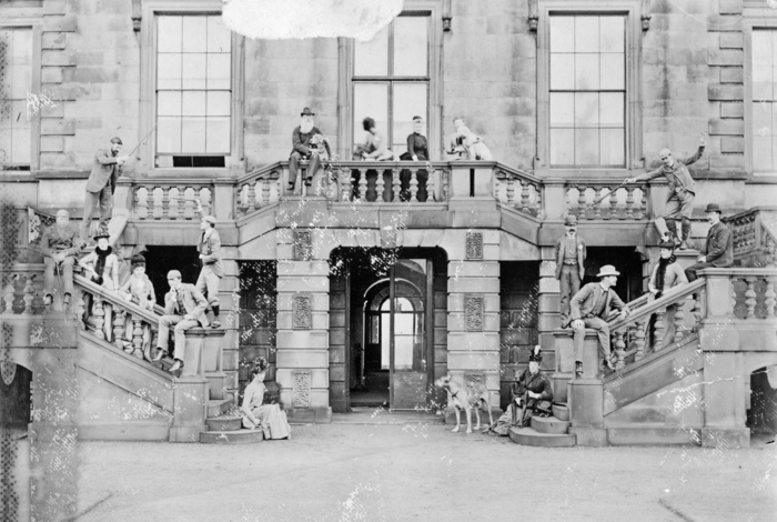 Lathom House, Lathom, Lancashire, 1885 1895. Creator: Unknown. Lathom House, Lathom, Lancashire, 1885 1895. A copy of a photograph showing a group of people on the double flight of steps at the south front of Lathom House, with some of the group adopting a playful pose. At the time the photograph was taken Lathom House was the home of the Bootle Wilbraham family and the Earl of Lathom. The bearded man sat on the balustrade at the top of the steps may be Edward Bootle Wilbraham, 1st Earl of Lathom  1837 1898 .