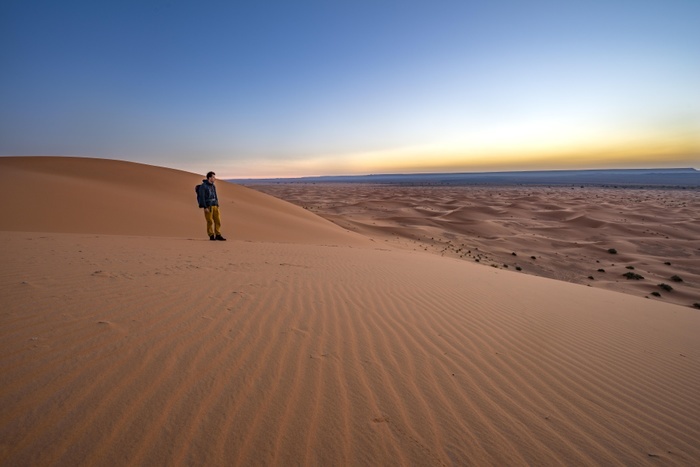 Morocco Young man on a sand dune at sunrise, Erg Chebbi, Merzouga, Sahara, Morocco, Africa, Photo by Mara Brandl